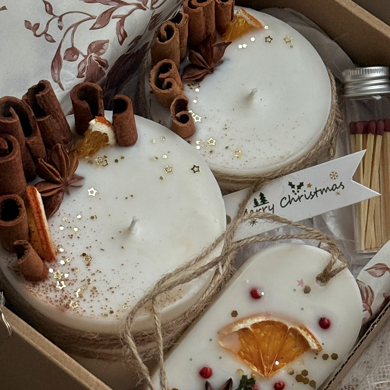 Decorative candles with cinnamon sticks and star anise in a gift box.