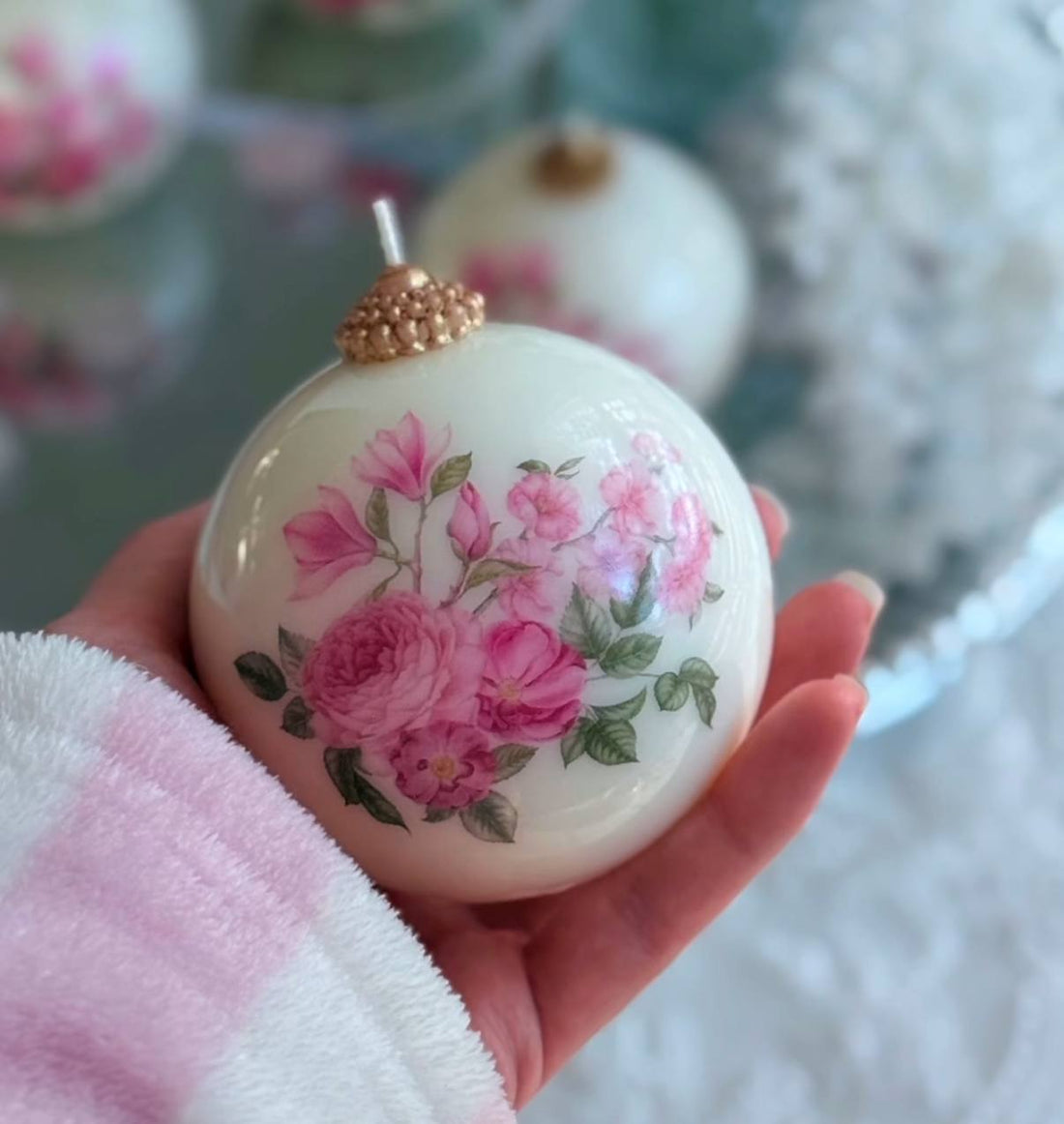 vintage floral ornament candle in hand

round soy beeswax candle with pink roses

gift box with ribbon for ornament candle

close-up floral decoupage on candle

ornament candle on holiday table decor