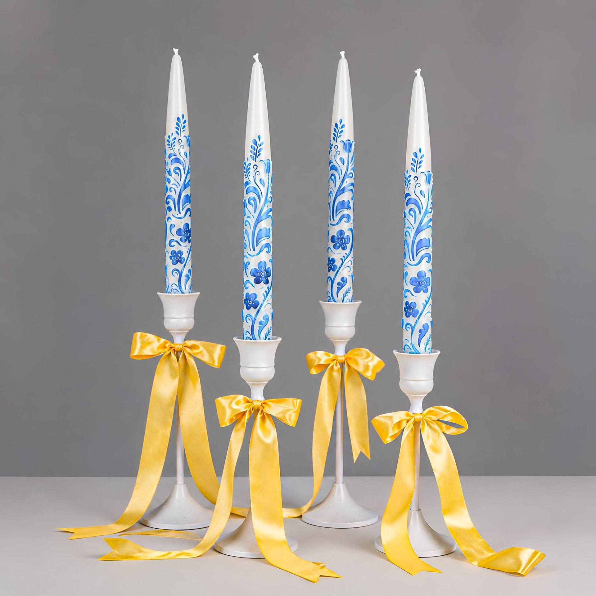 Blue and white floral taper candles with yellow satin ribbons